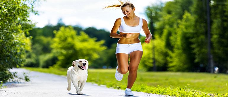 Спортивная девушка бежит с собакой